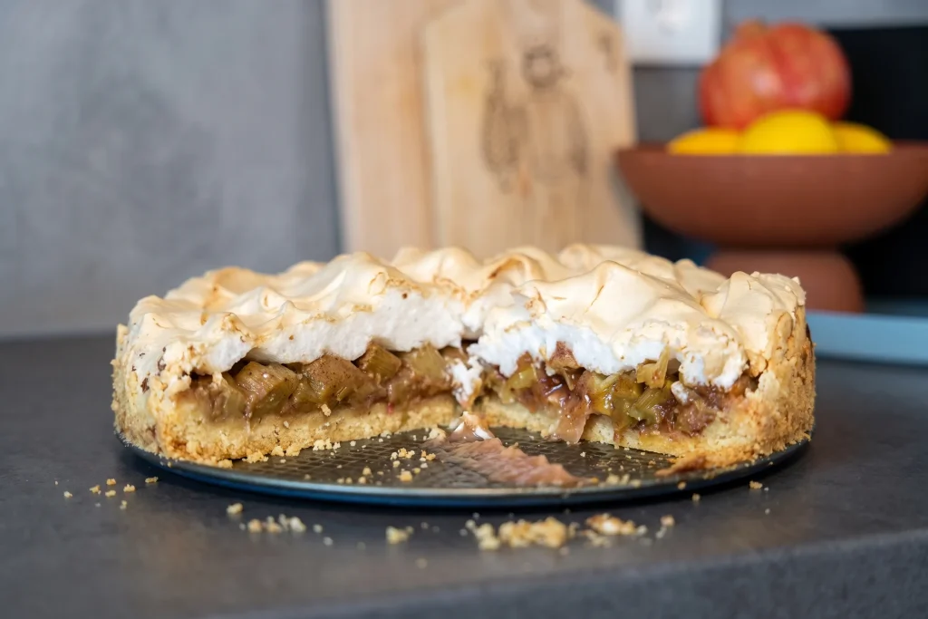Rhabarberkuchen mit Baiserhaube auf einem Teller, frisch gebacken.