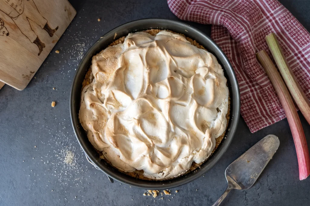 Rhabarberkuchen mit Baiserhaube in einer Backform.